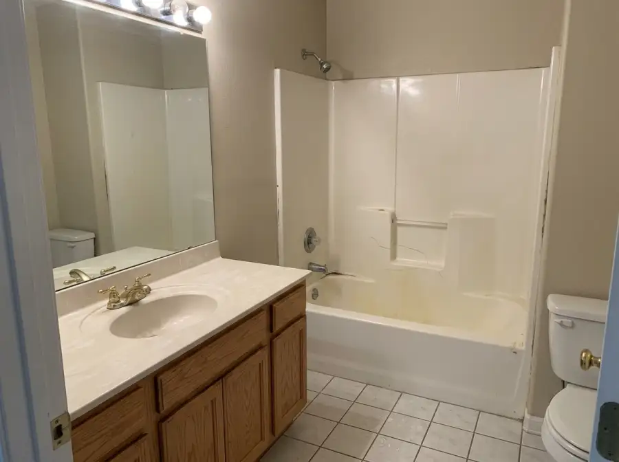 Yellowed, cracked acrylic tub-shower insert in a 1990s Southeast Boise home
